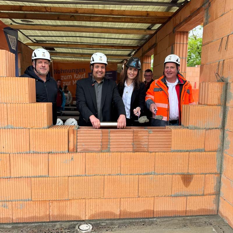 Roths Erster Bürgermeister Andreas Buckreus, Architektin Stephanie Kühnlein-Innig sowie der städtische Bauleiter Thomas Juraschek mauern symbolisch eine Zeitkapsel in den Grundstein ein.